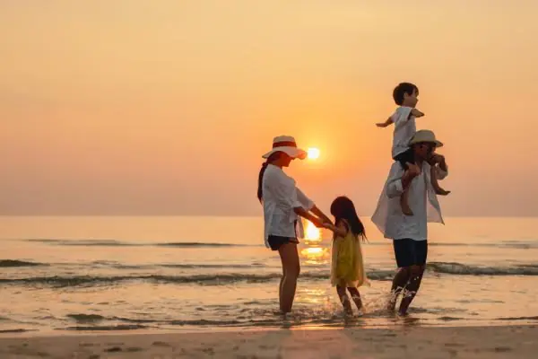 Familia unida viendo un atardecer en la playa