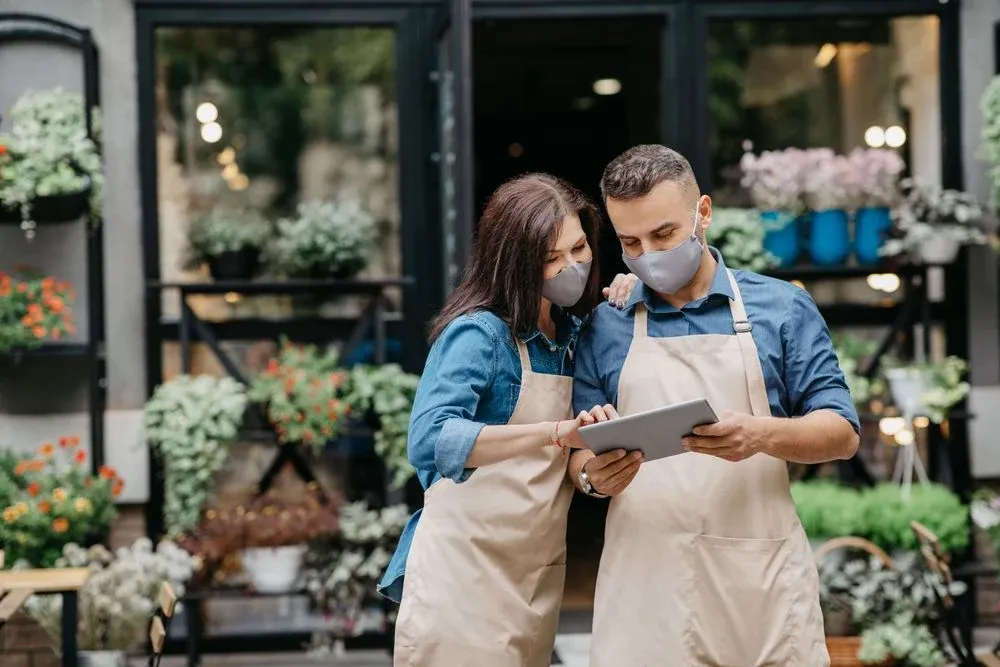Trabajadores de una floristeria viendo una tablet