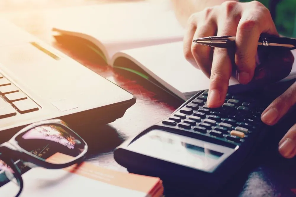 Persona usando una calculadora para saber sus deudas